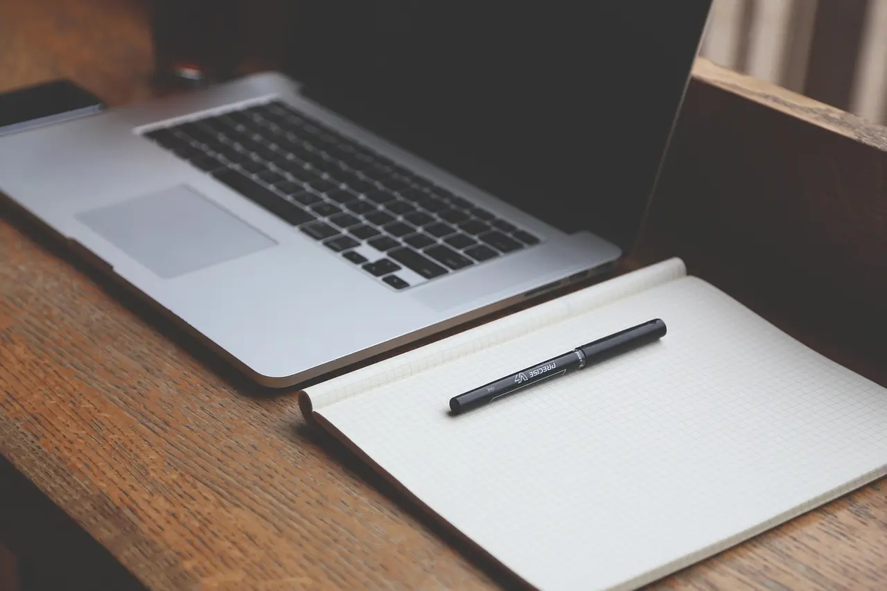 Laptop sa grafikonima i AI robot igračkom prikazuje SEO content automation radno okruženje